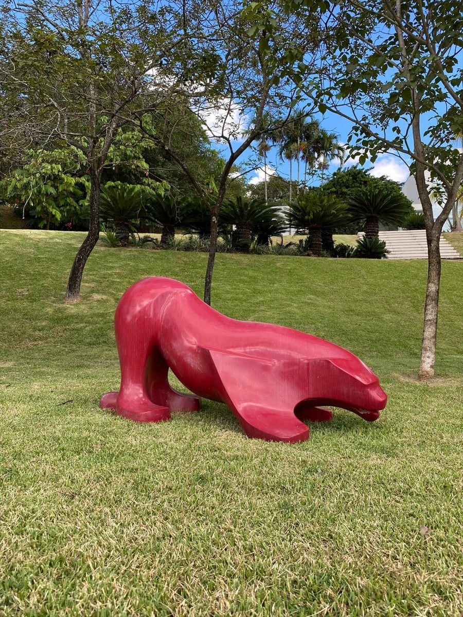 Escultura vermelha de animal em jardim